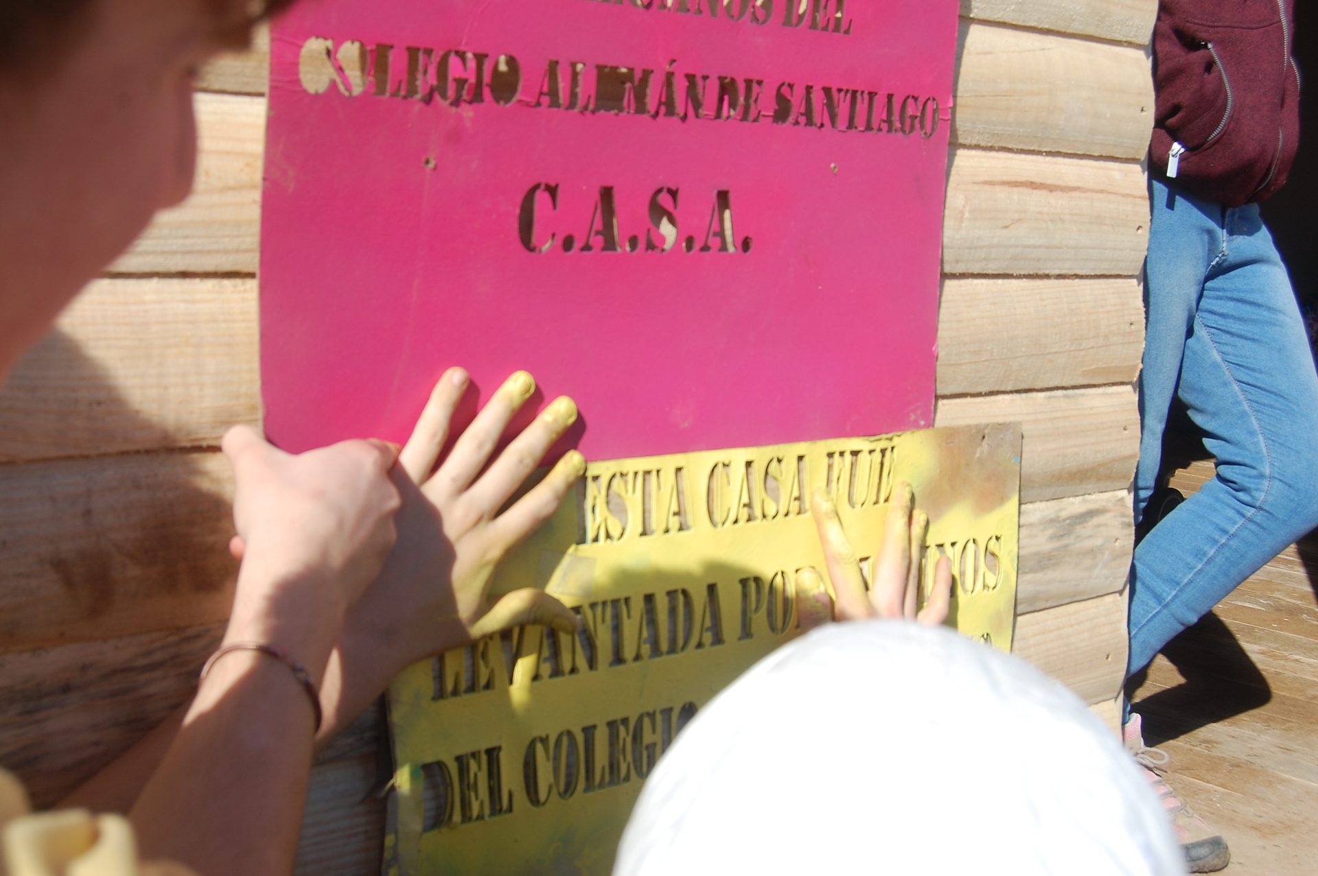 Alumnos pintando la placa stencil del C.A.S.A.